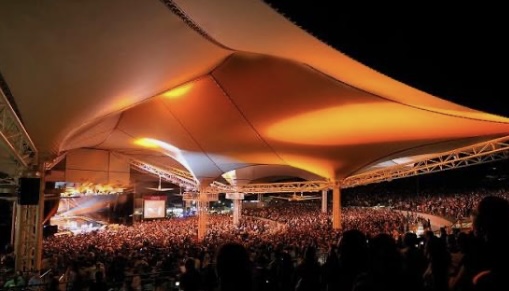 Nighttime concert at the Cynthia Woods Mitchell Pavilion in The Woodlands, Texas, showcasing vibrant community life